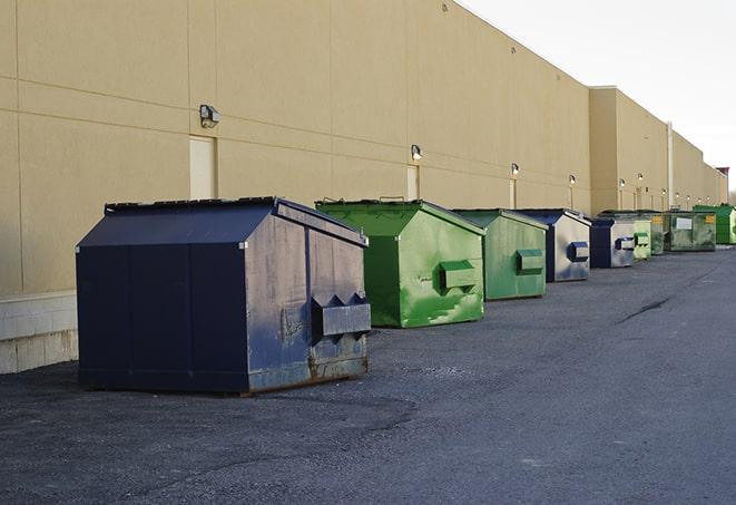 a pile of demolition waste sits beside a dumpster in a parking lot in Millers Falls